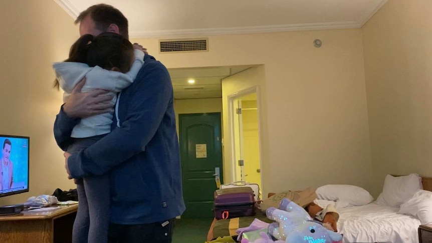 Jarrod Whittaker hugs his daughter in hotel isolation