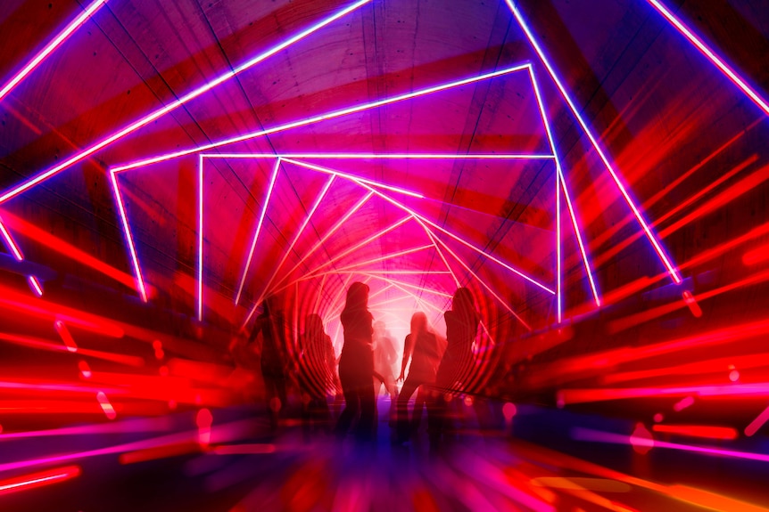 people in an underground space with light projections 