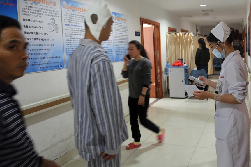 A brain surgery patient walks down the corridor of Ruijin Hospital's neurosurgery centre.