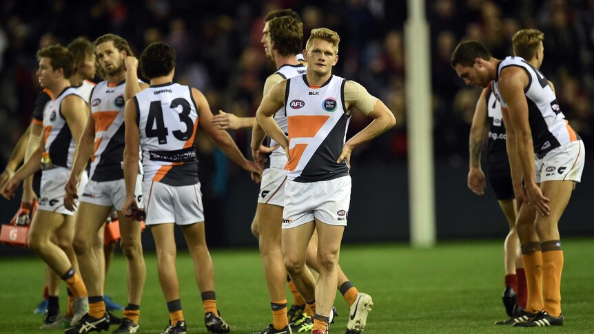 GWS player Adam Treloar (C) reacts with team-mates after a loss to Melbourne in round 23, 2015.