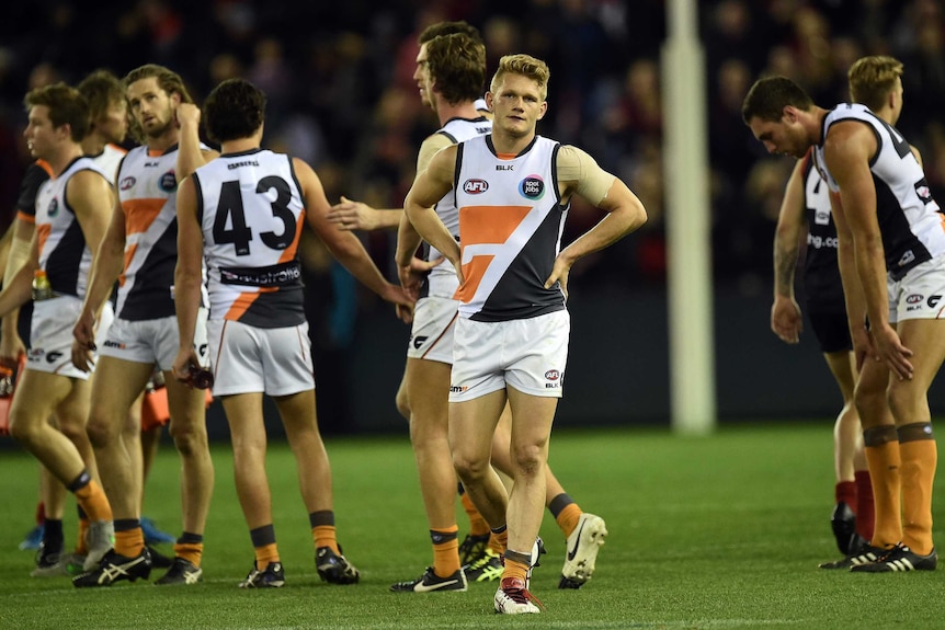 GWS player Adam Treloar (C) reacts with team-mates after a loss to Melbourne in round 23, 2015.