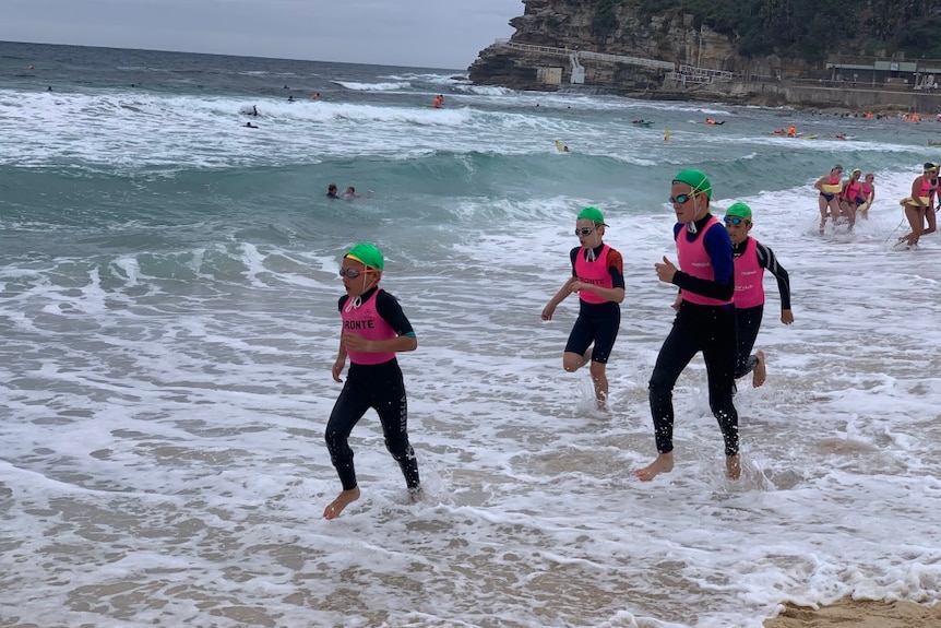 Young boys running along the shoreline 