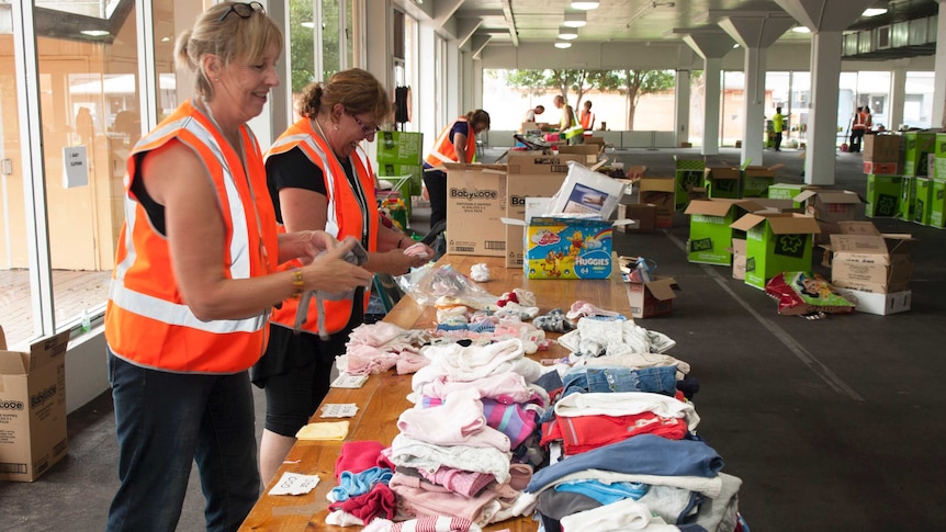 Teresa Robertson and Liza Huston fold and sort donations.