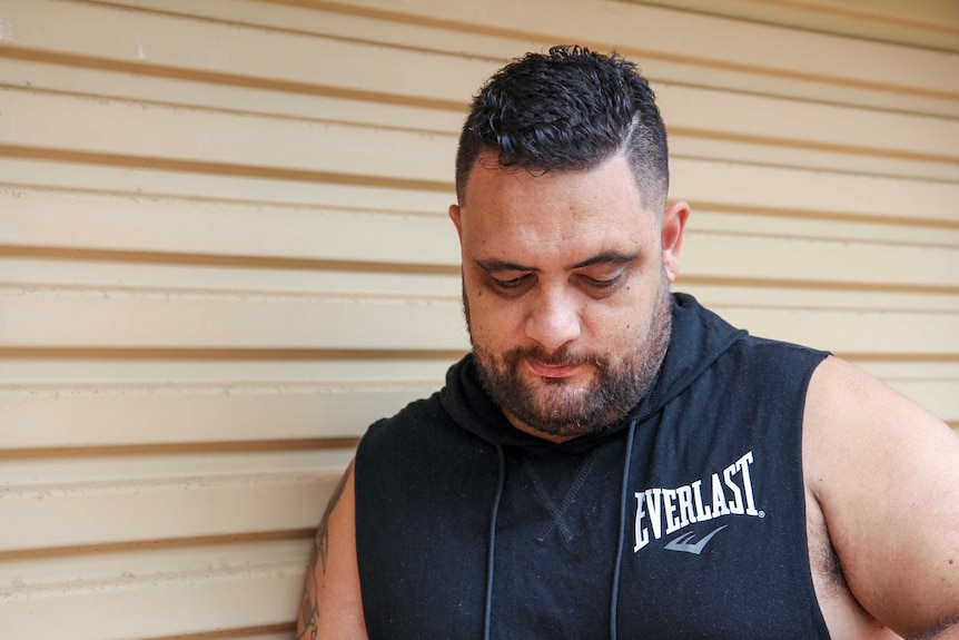 A New Zealand man looks down at his feet.