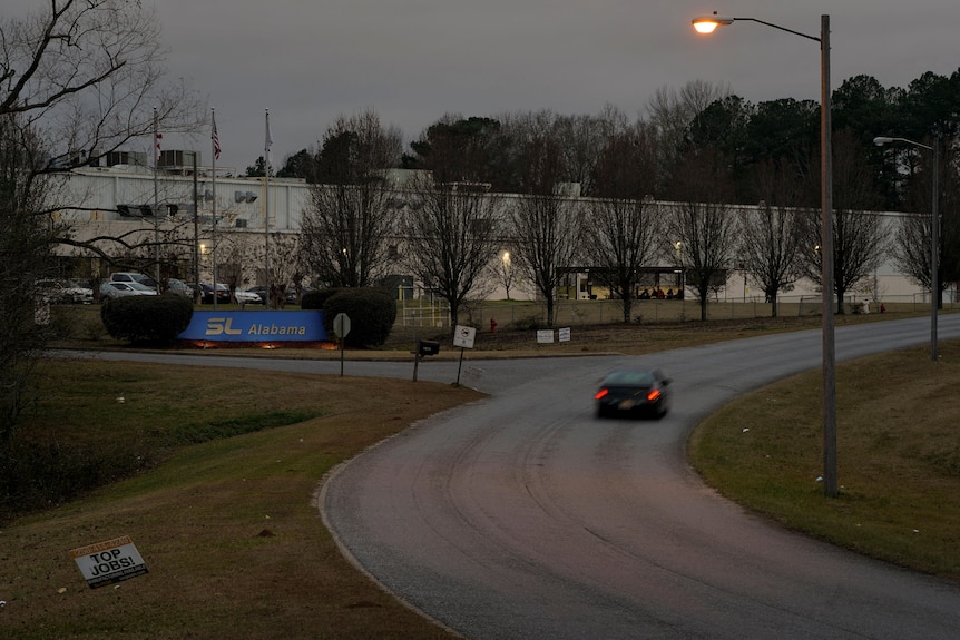 a car drives on a road outside the SL Alabama facility in Alexander City