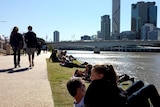 People enjoy the winter sunshine beside the Brisbane River