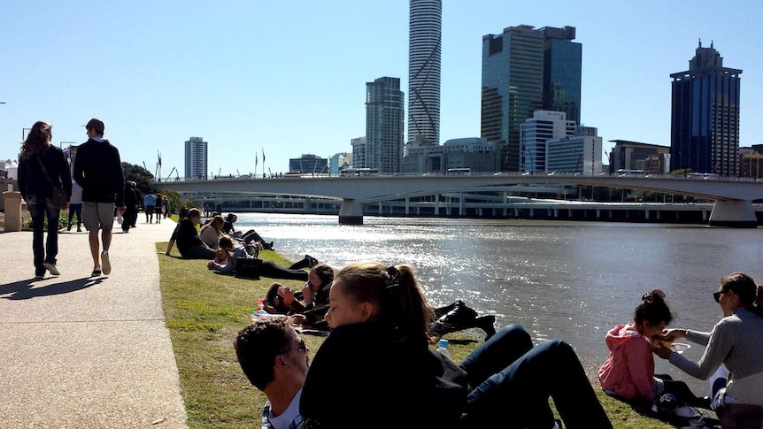 People enjoy the winter sunshine beside the Brisbane River