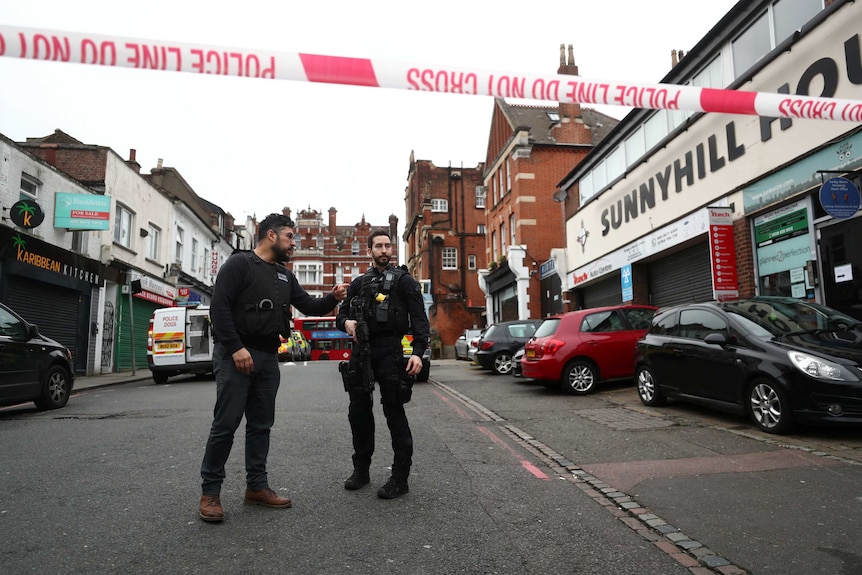 Two police officers stand in a street after an incident