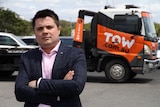 tow.com.au CEO Dominic Holland poses in front of a company truck