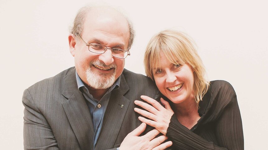 Salman Rushdie and Caro Llewellyn in a friendly pose with their hands on each others' shoulders.