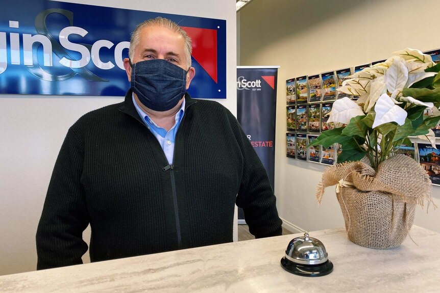 a man with a mask on in a real estate agency