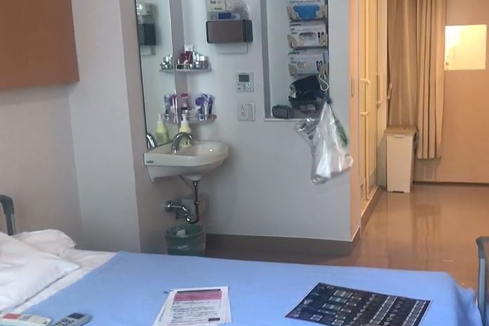 A shot of a hospital room including a sink and bed