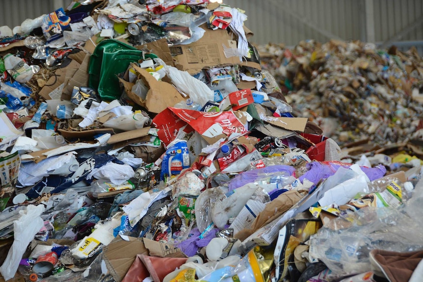 A big pile of rubbish in an industrial warehouse.