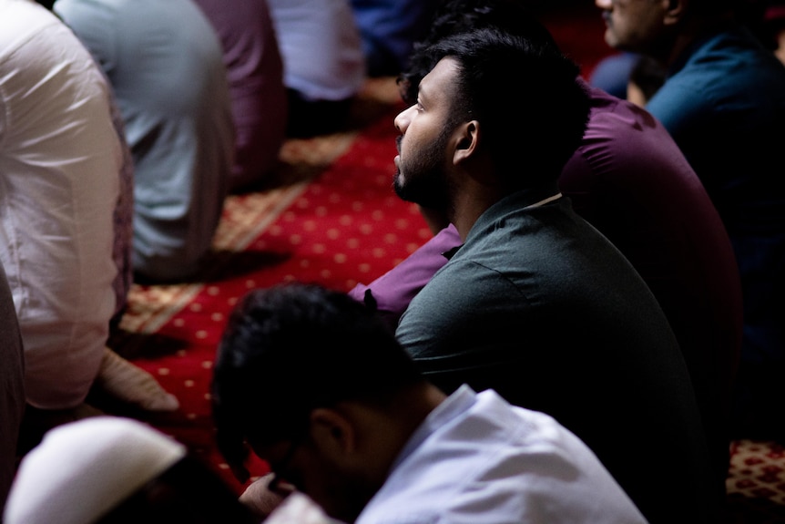 A man looks up during prayer at the Darwin Mosque.