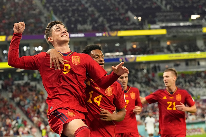 Gavi jumps in the air as Spain teammates run to him after a goal against Costa Rica at the Qatar World Cup.