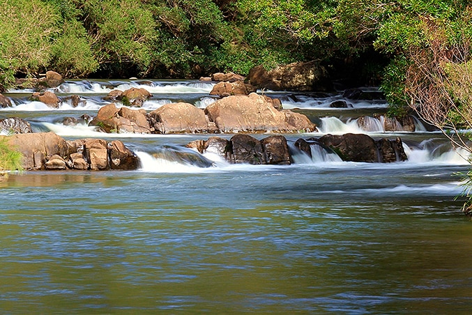 Rock formations in a river during normal water flow forms a rapids