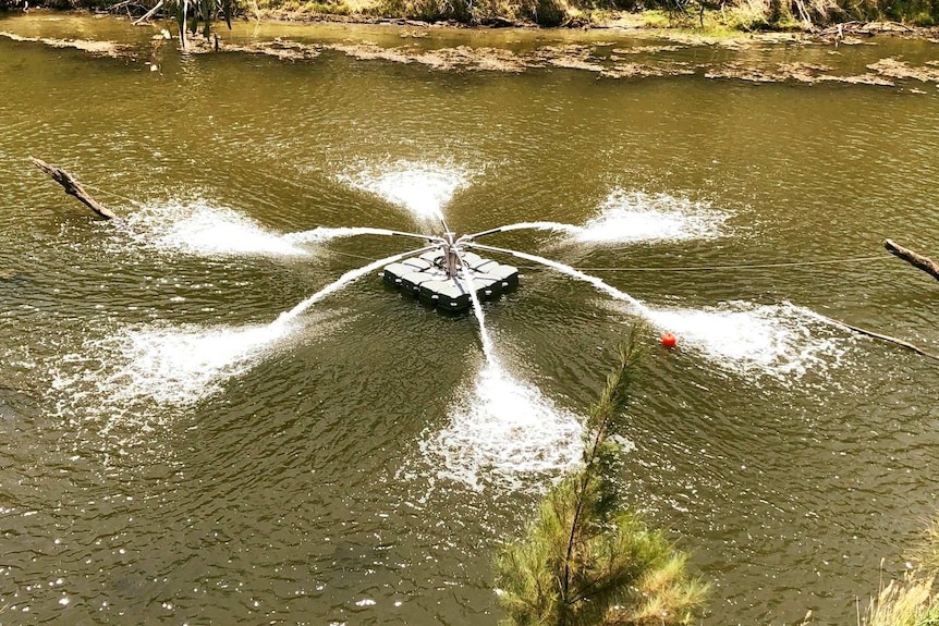 An aerating device, which looks like a small platform with sprinkler-type fittings, operating in a river.