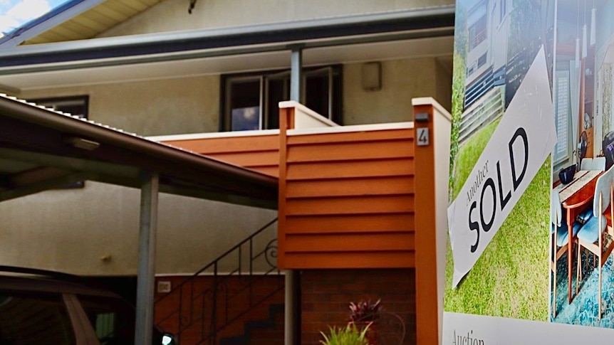 the front of a bungalow with a sold sign 