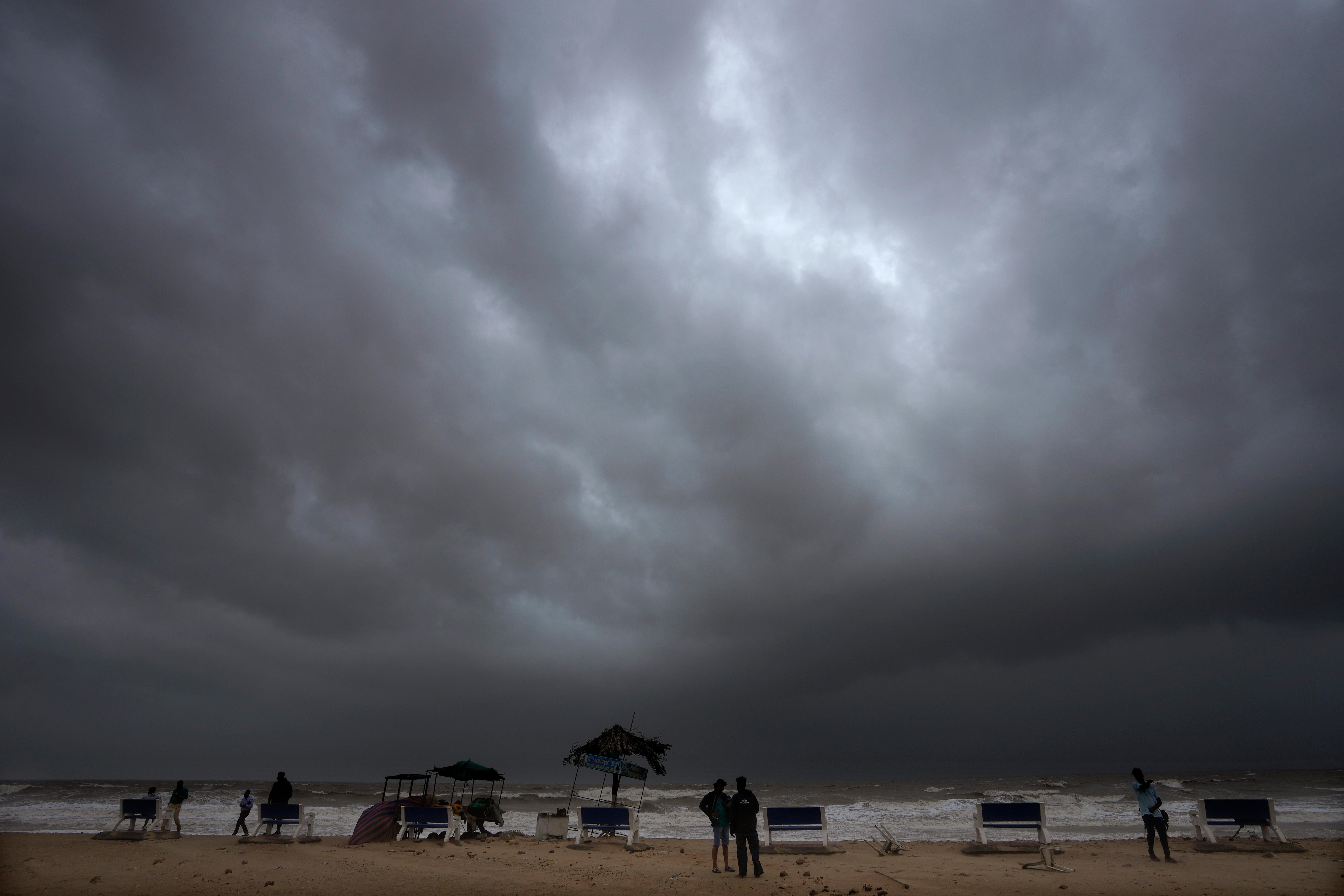 Rain clouds fill the sky at a deserted beach. 