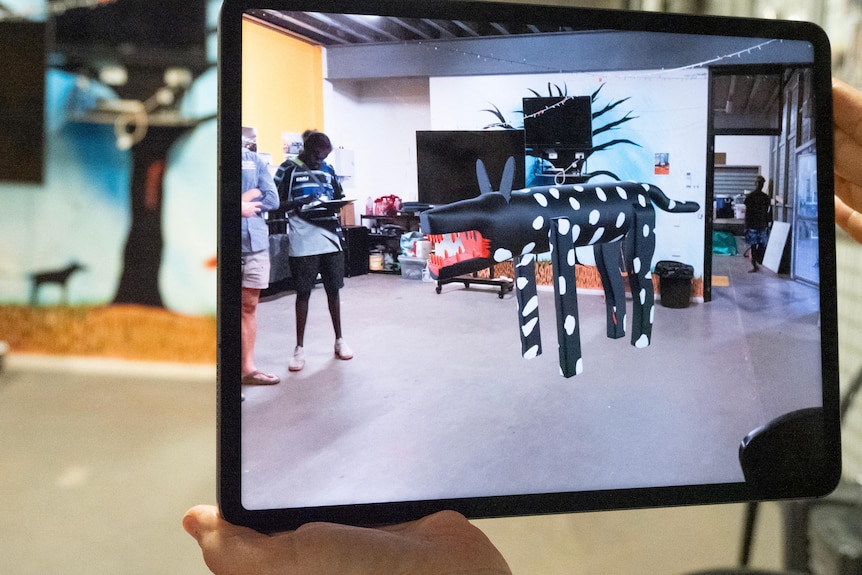 A large digital dog statue, projected into a room next to a young man.
