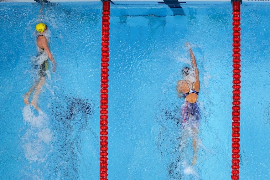 Ariarne Titmus touches the pool wall ahead of Katie Ledecky at the Tokyo Aquatics Centre.