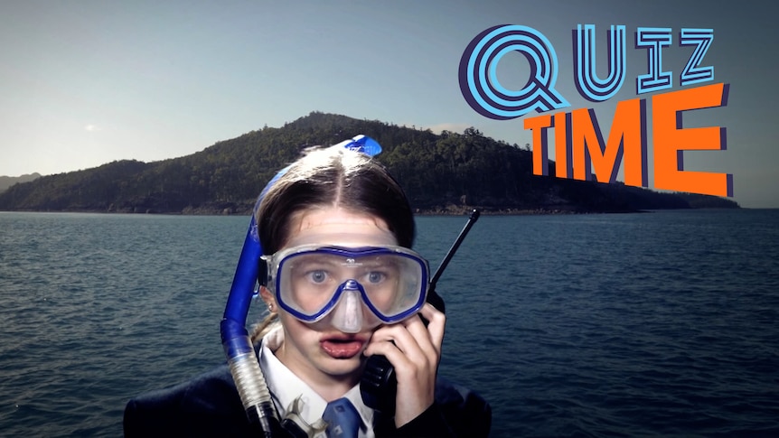 A student actor dressed as a government official but wearing a snorkle and mask speaking into a walkie-talkie.