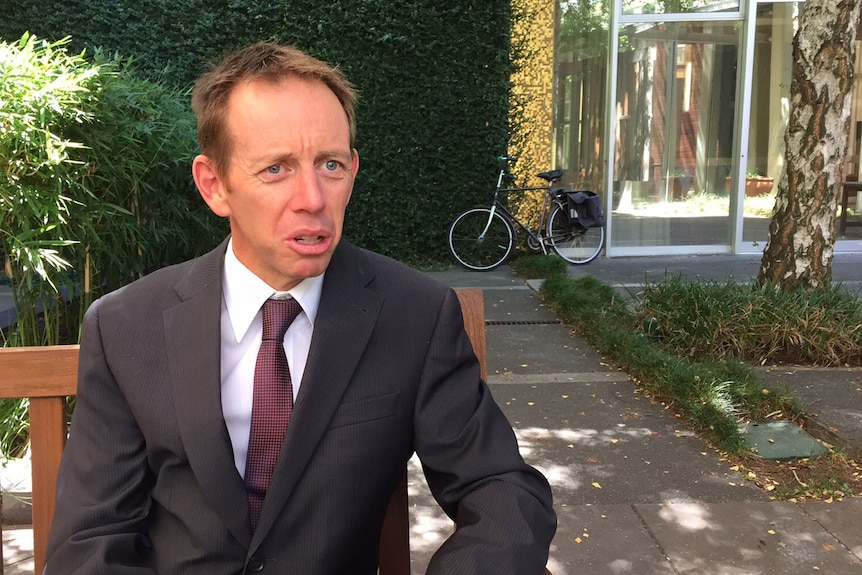 Shane Rattenbury with a bicycle in the background.