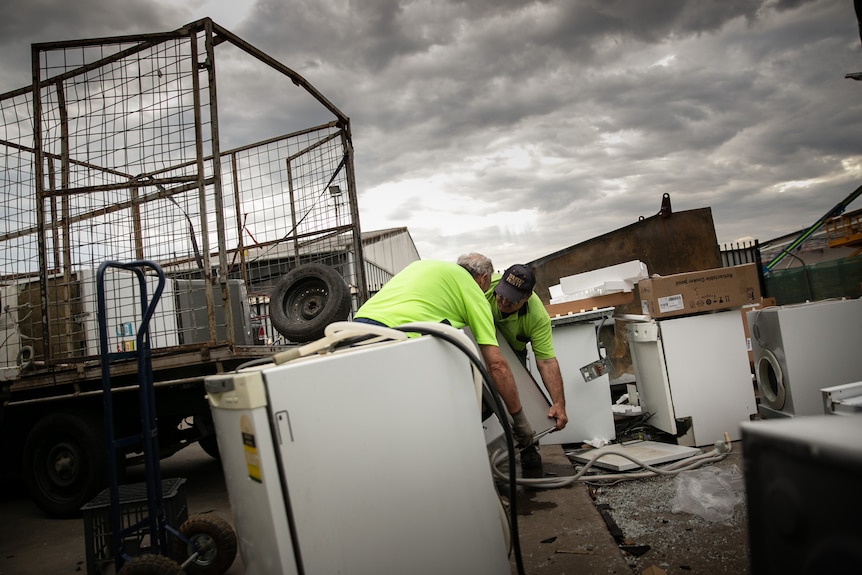 Andrew and his friend Bob lift a washing machine.