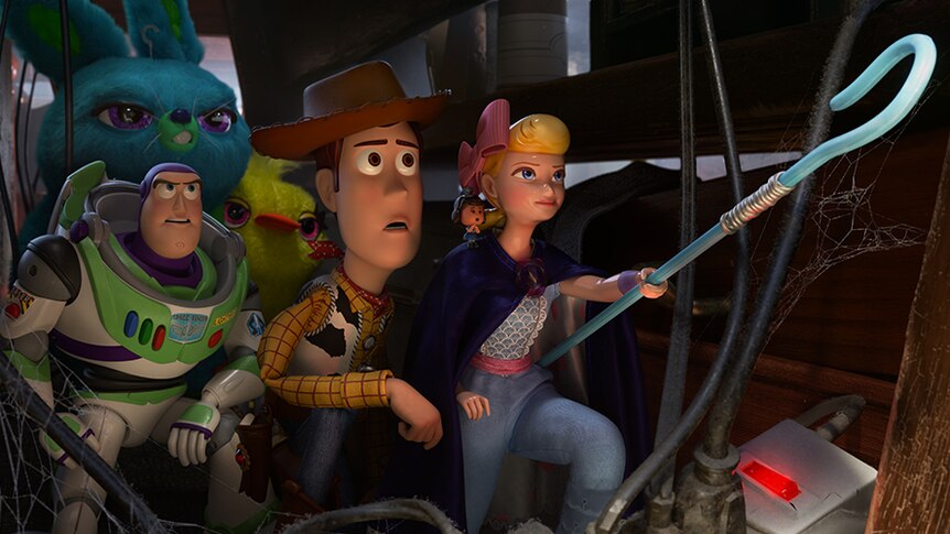 Colour still of Woody, Buzz Lightyear, Ducky, Bunny standing behind Bo Peep pointing her blue staff in 2019 film Toy Story 4.