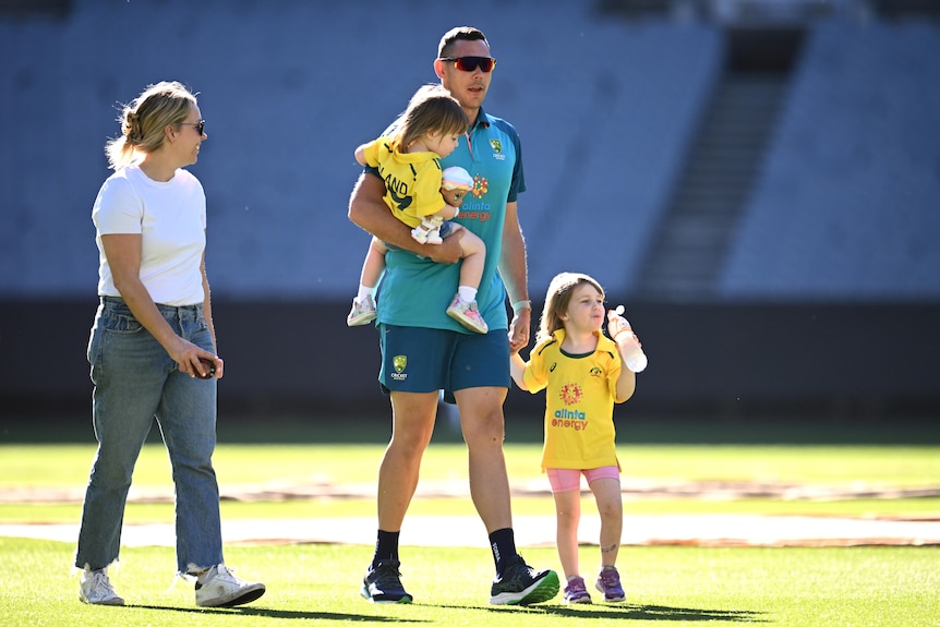 Scott Boland walks with his wife Clarissa and their two children