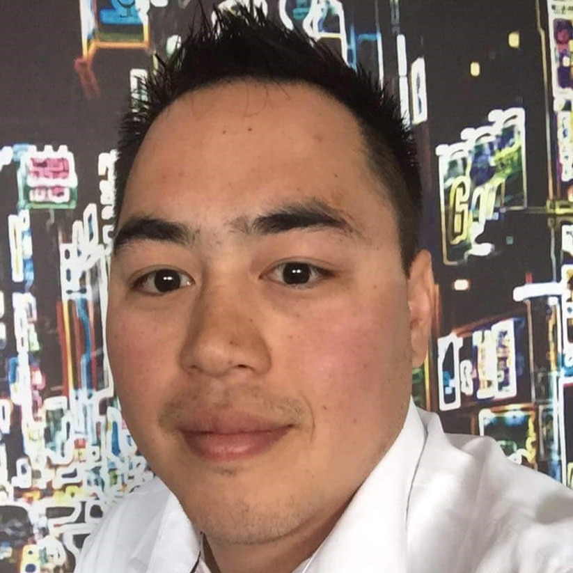 A headshot of Andrew Doan in a white shirt with a city skyline neon lights in the background