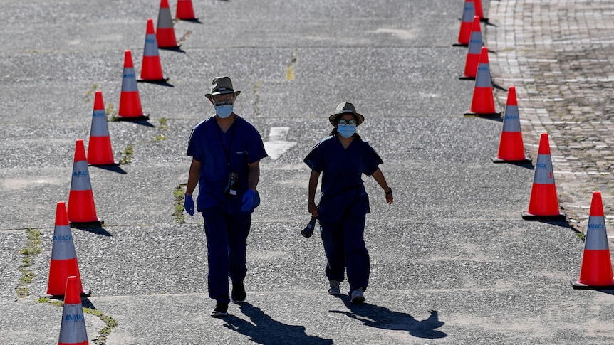 Two healthcare workers walking along a road