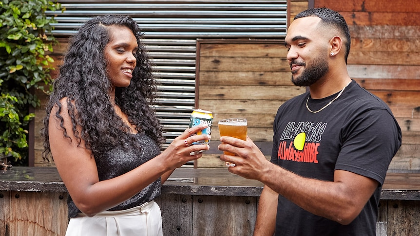 A man and women cheers with non-alcoholic beer.