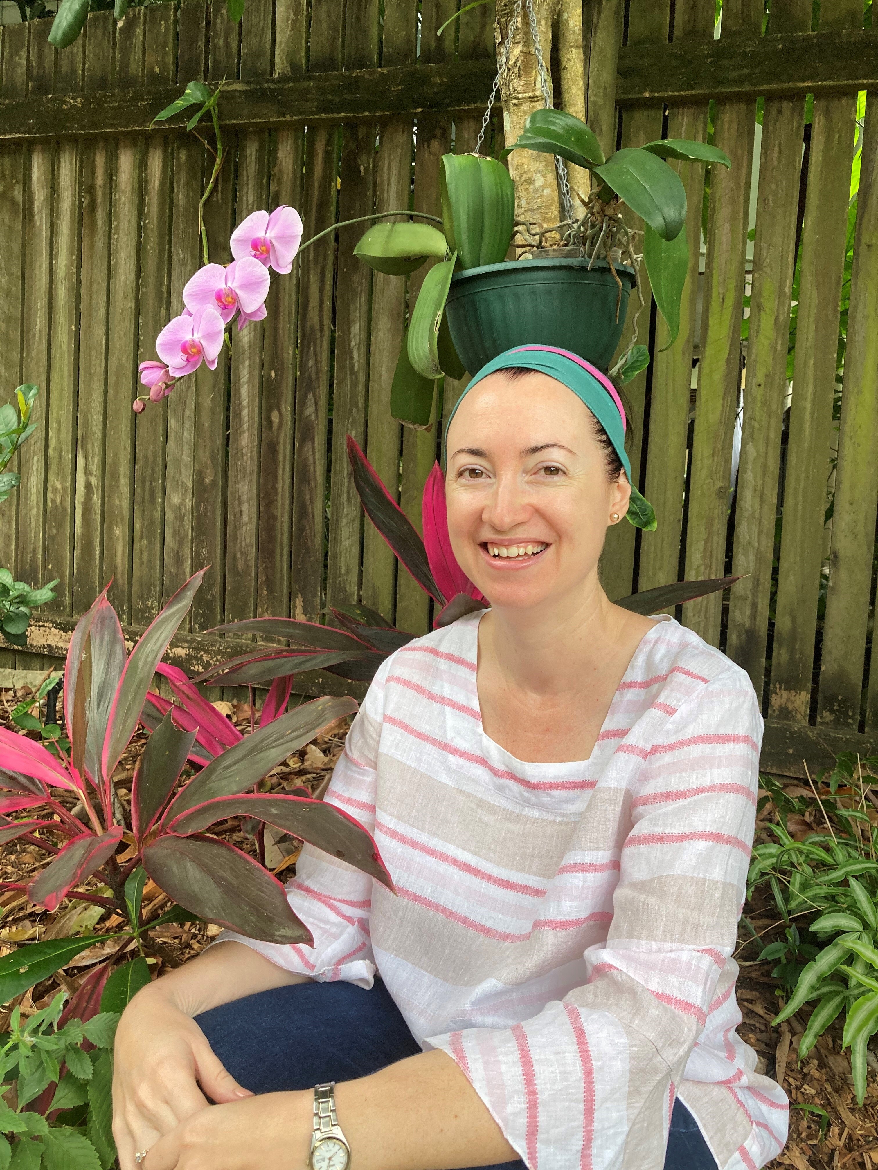 A young woman sitting in the garden, smiling.
