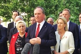 Nationals leader Barnaby Joyce stands at a microphone flanked by his colleagues at a press conference in Canberra.