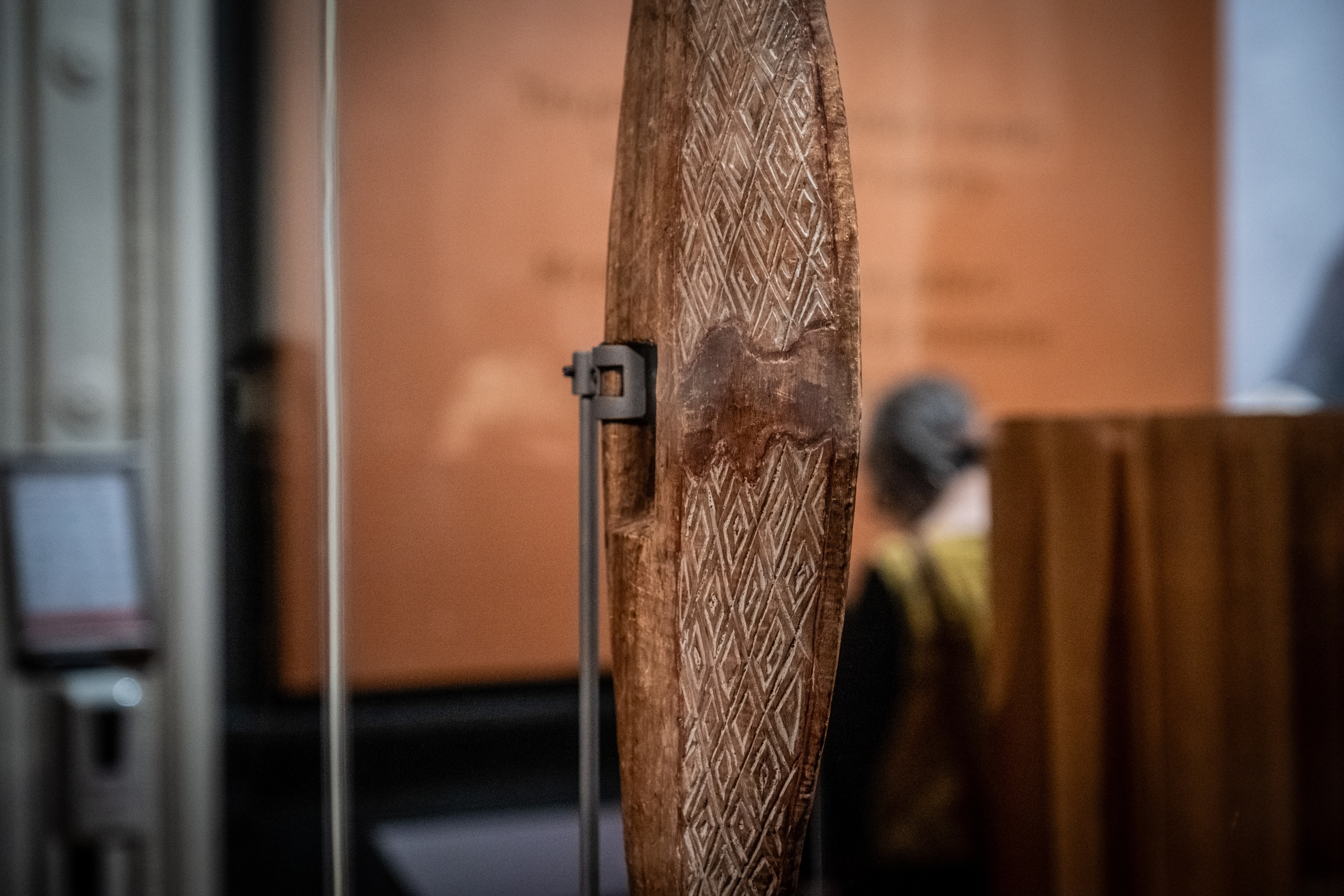 A Parrying Shield created by William Barak with carvings in an exhibition.