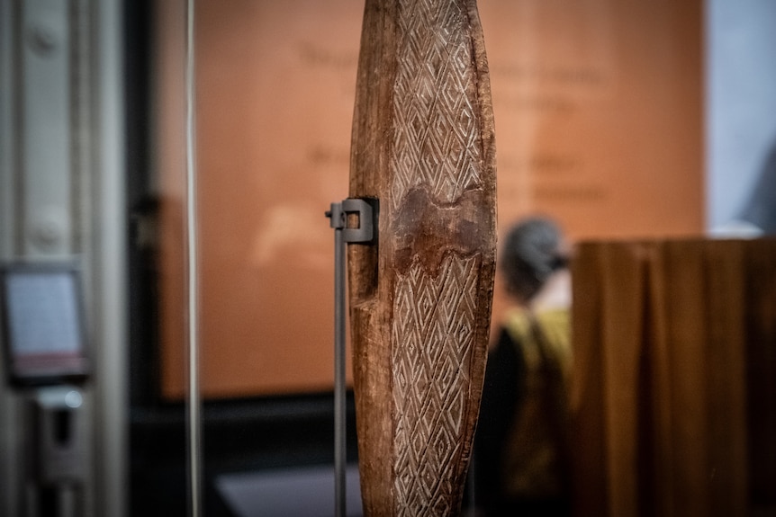 A Parrying Shield created by William Barak with carvings in an exhibition.