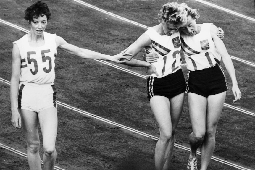 Betty Cuthbert and Judy Amoore hug while Ann Packer extends an arm to them.