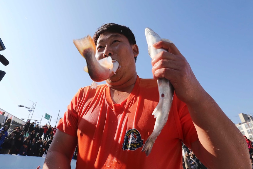 Man puts trout in his mouth