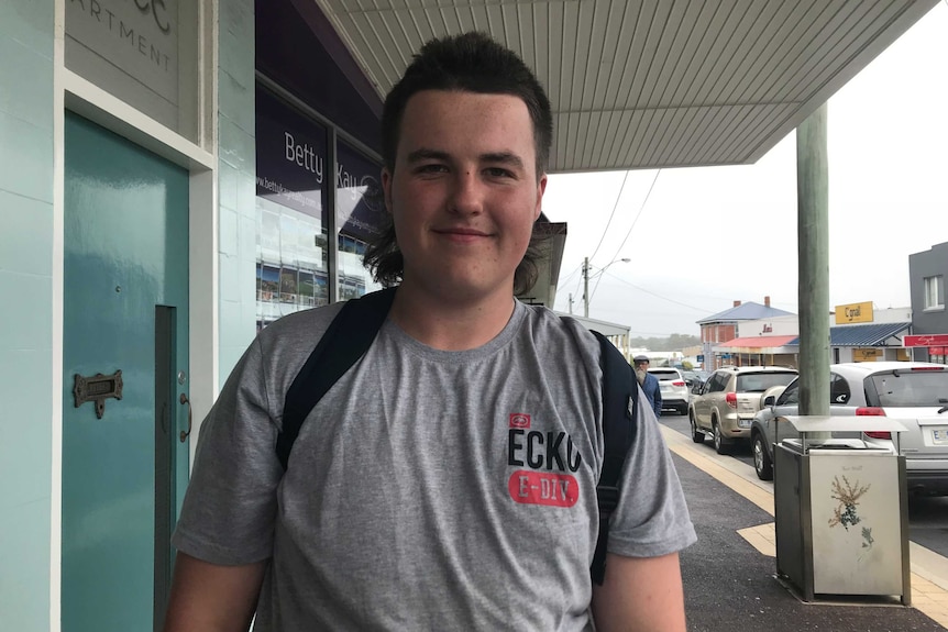 A man poses for a photo on the street.