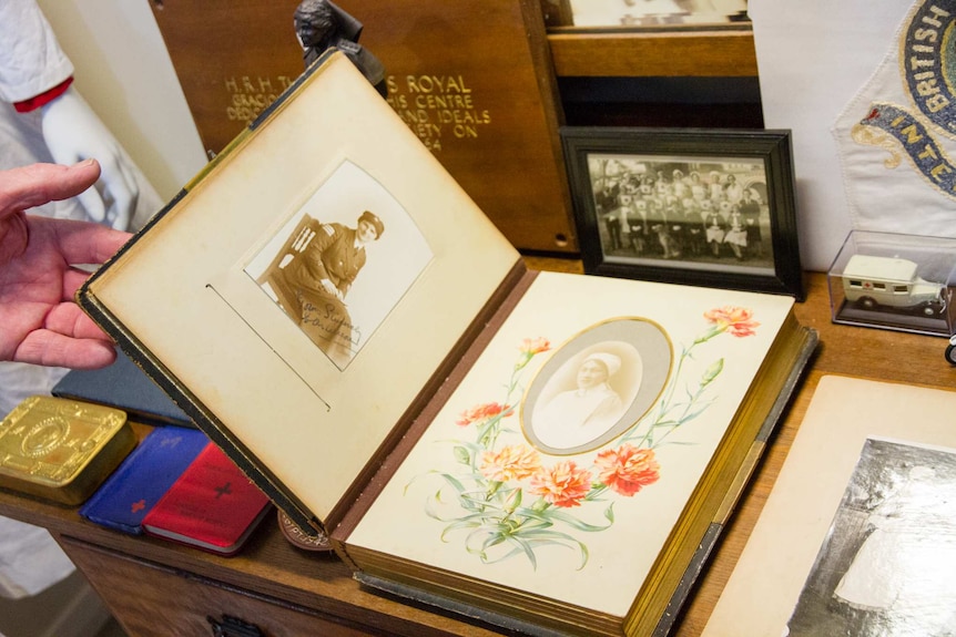 A man holding an old photograph album open