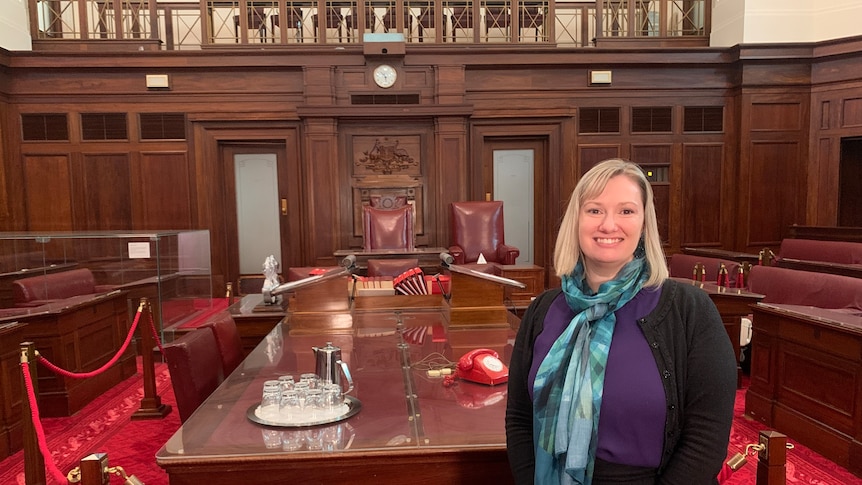 A woman stands in the Senate chamber at Old Parliament House