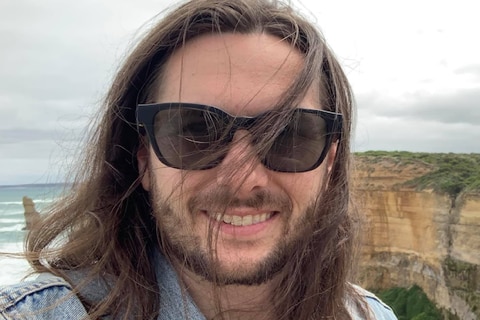 A young man with long hair and sunglasses