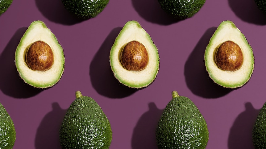 Halved avocados on a purple background, in a story about how to choose, store and eat Hass and Shepard avocados