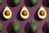 Halved avocados on a purple background, in a story about how to choose, store and eat Hass and Shepard avocados