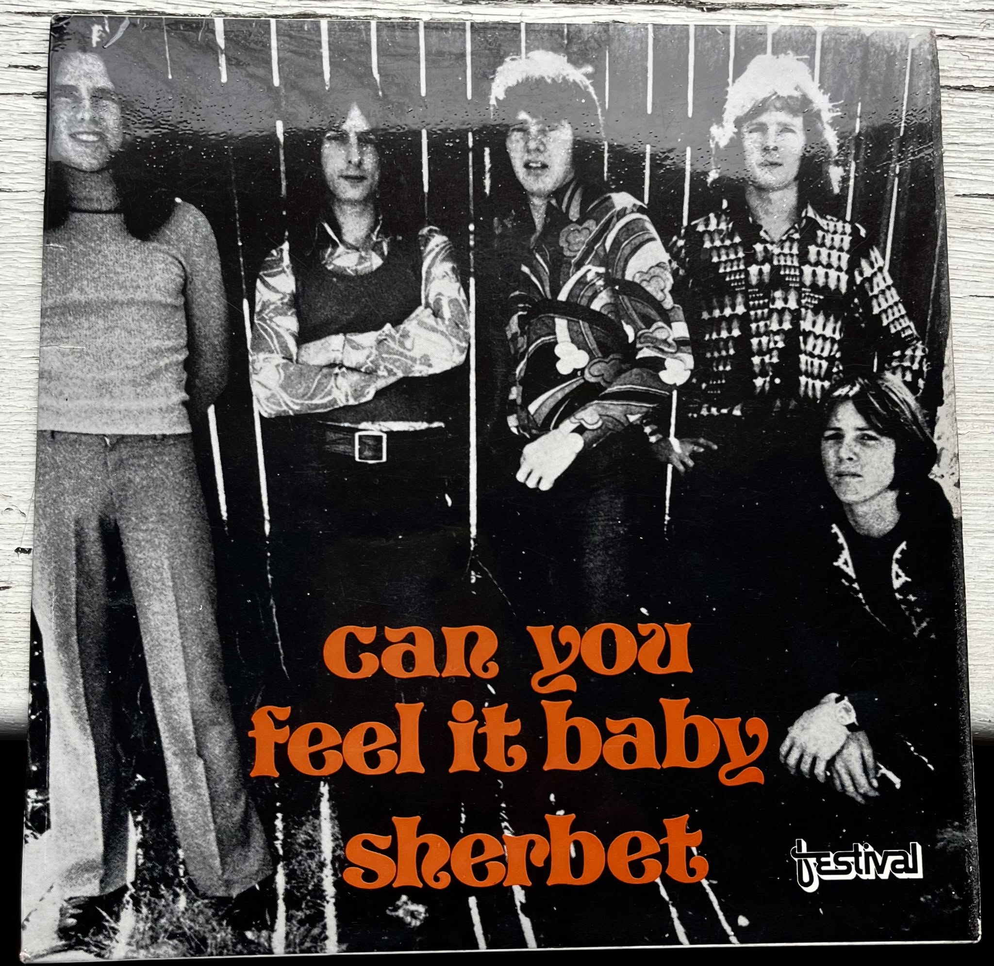 A black and white album cover with five men and orange writing saying "can you feel it baby, sherbert".