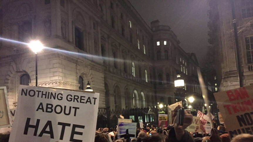 UK protesters hold up signs as they protest Donald Trump's travel ban