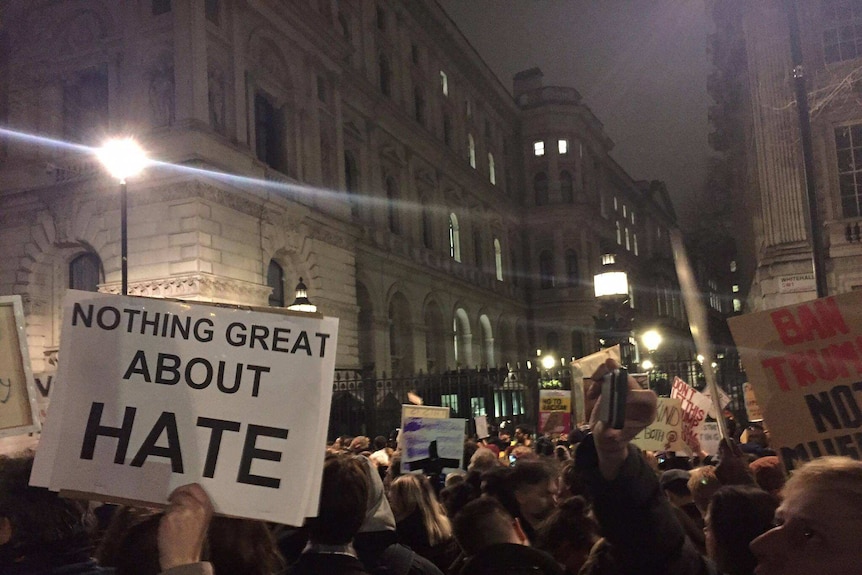 UK protesters hold up signs as they protest Donald Trump's travel ban
