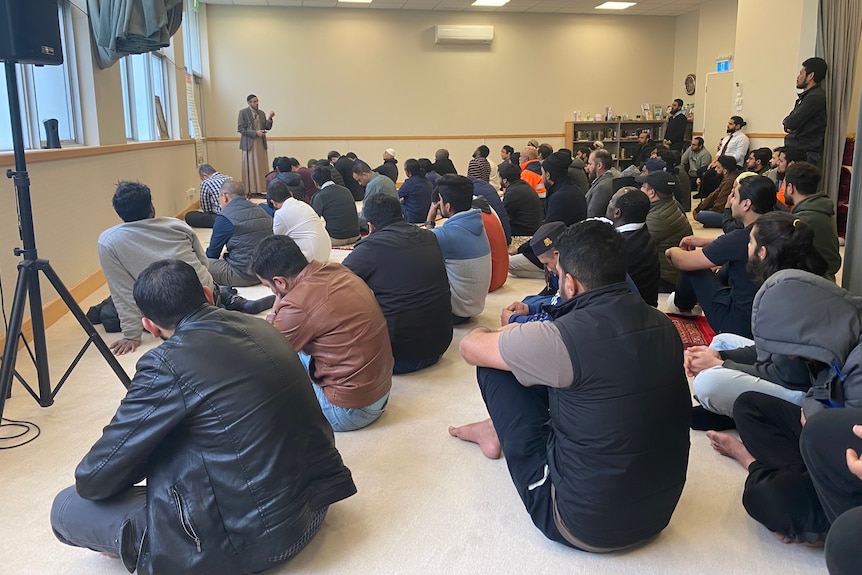 Muslim men praying in a room. 