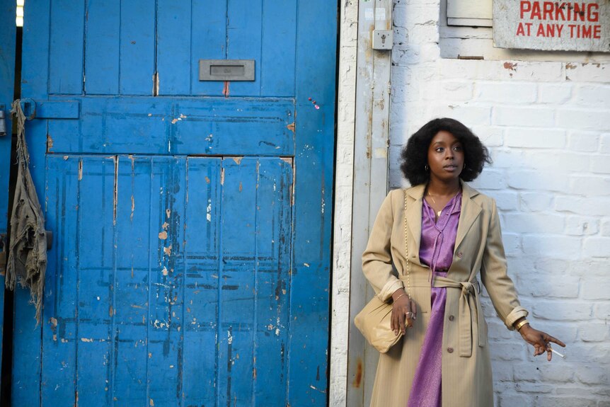 A still from the film Lovers Rock with actor Amarah-Jae St. Aubyn standing in front of a wall, in 70s clothes